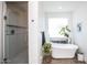 Modern bathroom with glass-enclosed shower, standalone tub, and stylish accents at 4115 E Windsor Ave, Phoenix, AZ 85008