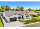 A charming exterior showcasing a well-manicured lawn, a black garage door, and tasteful landscaping at 4115 E Windsor Ave, Phoenix, AZ 85008