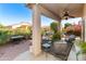 Inviting covered patio area with a ceiling fan, seating, and views of lush landscaping at 4674 E Alfalfa Dr, Gilbert, AZ 85298