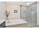 Bright bathroom features a luxurious soaking tub with marble surround and a separate glass-enclosed shower at 4803 N Woodmere Fairway -- # 3009, Scottsdale, AZ 85251