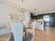 Modern dining area features stylish light fixture, glass table and four chairs, open to kitchen at 4803 N Woodmere Fairway -- # 3009, Scottsdale, AZ 85251