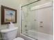Bathroom showing enclosed shower and tub with glass doors and wall decor at 5234 E Carol Ave, Mesa, AZ 85206