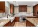 Charming kitchen featuring a farmhouse sink, granite countertops, and stainless steel appliances at 5234 E Carol Ave, Mesa, AZ 85206
