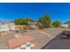 View of gravel backyard featuring trees, partial landscaping, and a stone paver patio area at 5732 E Covina Rd, Mesa, AZ 85205