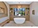 Modern bathroom featuring a soaking tub, and large window providing natural light at 5812 N 44Th Pl, Phoenix, AZ 85018