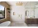 Bright bathroom featuring a glass enclosed shower, sleek soaking tub, modern fixtures, and natural light from the window at 5812 N 44Th Pl, Phoenix, AZ 85018