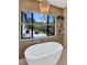 Modern bathroom featuring a soaking tub, view of backyard and patio at 5812 N 44Th Pl, Phoenix, AZ 85018