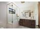 Bathroom featuring a glass enclosed shower, vanity with wood cabinets, designer mirror, and elegant fixtures at 5812 N 44Th Pl, Phoenix, AZ 85018