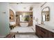 Bright bathroom with a glass enclosed shower, soaking tub, and double vanity with wood cabinets and gold fixtures at 5812 N 44Th Pl, Phoenix, AZ 85018