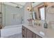 Elegant bathroom featuring a luxurious bathtub, glass shower, and sleek fixtures with marble flooring at 5812 N 44Th Pl, Phoenix, AZ 85018