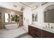 Bright bathroom with soaking tub, double vanity, and a glass enclosed shower with modern fixtures and a herringbone accent wall at 5812 N 44Th Pl, Phoenix, AZ 85018