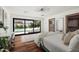 Bright main bedroom features hardwood floors, a large sliding glass door with a pool view, and a modern ceiling fan at 5812 N 44Th Pl, Phoenix, AZ 85018