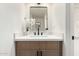 A sleek powder room features a wood vanity, black hardware, and a modern mirror, creating a stylish and functional space at 6841 E Osborn Rd # C, Scottsdale, AZ 85251