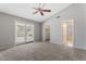 Bright bedroom featuring plush carpeting, ceiling fan, and sliding glass doors to outdoor space at 723 E Piute Ave, Phoenix, AZ 85024