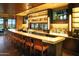 Stylish bar area with modern lighting, comfortable seating, and a wide selection of beverages on display at 7681 W Meadowlark Way, Florence, AZ 85132
