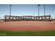 Well-maintained baseball field with covered seating, manicured red dirt, and vibrant green grass at 7681 W Meadowlark Way, Florence, AZ 85132