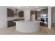 Well-lit kitchen featuring stainless steel appliances, an island with a sink, and dark wood cabinets at 7681 W Meadowlark Way, Florence, AZ 85132