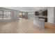 Open-concept living room with light wood-look tile flooring, kitchen view, and sliding glass doors at 7681 W Meadowlark Way, Florence, AZ 85132