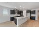 Stylish kitchen with granite island, stainless steel appliances, and dark cabinets at 7723 W Cactus Wren Way, Florence, AZ 85132