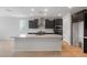 Modern kitchen with a large island, granite countertops, stainless steel appliances, and dark cabinets at 7723 W Cactus Wren Way, Florence, AZ 85132