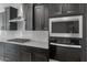 Modern kitchen featuring stainless appliances, dark cabinets, granite countertops and subway backsplash at 7723 W Cactus Wren Way, Florence, AZ 85132