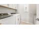 Well-equipped laundry room with modern washer and dryer units, storage, and countertops at 7836 W Mockingbird Way, Florence, AZ 85132