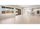 Open-concept living room seamlessly connecting to the kitchen, featuring tiled floors and large windows at 7836 W Mockingbird Way, Florence, AZ 85132