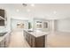 Bright kitchen boasts a large island with a sink and stainless gas cooktop, open to the living area at 7870 W Mockingbird Way, Florence, AZ 85132