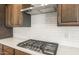 This kitchen features a gas cooktop, quartz counters, subway tile backsplash, and stainless vent hood at 7870 W Mockingbird Way, Florence, AZ 85132