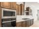 Gourmet kitchen boasts stainless appliances, quartz countertops, subway tile, gas cooktop, and wood cabinets at 7870 W Mockingbird Way, Florence, AZ 85132