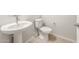 Cozy powder room with a pedestal sink, toilet, and wood-look tile flooring at 7870 W Mockingbird Way, Florence, AZ 85132