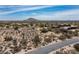 Expansive aerial view of a luxury desert home with mountain views, next to a paved road at 8395 E Leaning Rock Rd # 187, Scottsdale, AZ 85266