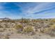Open desert land with sparse vegetation, residential buildings, and distant mountain views at 8395 E Leaning Rock Rd # 187, Scottsdale, AZ 85266