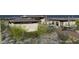 Desert-landscaped home with flat roofs and contemporary design, featuring a driveway with luxury cars at 8395 E Leaning Rock Rd # 187, Scottsdale, AZ 85266