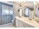 Bathroom with a large vanity and sink, complemented by blue floral patterned wallpaper and a shower with glass doors at 8600 E Broadway Rd # 28, Mesa, AZ 85208