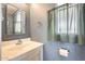 This bathroom features a sink, a mirror, patterned wallpaper, and a window with green curtains at 8600 E Broadway Rd # 28, Mesa, AZ 85208
