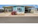 Charming blue home featuring a carport, desert landscaping, and eye-catching magenta cactus in the front yard at 8600 E Broadway Rd # 28, Mesa, AZ 85208