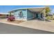 Inviting blue home featuring a carport, desert landscaping, and eye-catching magenta cactus in the front yard at 8600 E Broadway Rd # 28, Mesa, AZ 85208