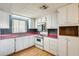 Well-lit kitchen with white cabinets and appliances, pink countertops, and a double basin sink under the window at 8600 E Broadway Rd # 28, Mesa, AZ 85208