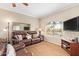 Relaxing living room with plush seating, a large window, and a mounted television at 10030 W Indian School Rd # 226, Phoenix, AZ 85037