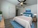 Well-lit bedroom with a ceiling fan, carpeted floor, light blue rug and modern furniture at 10401 N 52Nd St # 124, Paradise Valley, AZ 85253