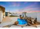 Backyard oasis featuring a sparkling blue pool, rock waterfall feature and a well-maintained patio space at 10505 W Wilshire Dr, Avondale, AZ 85392