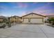 Charming single-Gathering home showcasing a wide driveway, desert landscaping and a three-car garage at 10505 W Wilshire Dr, Avondale, AZ 85392