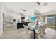 Modern kitchen with sleek white cabinets, a large island, and an adjacent dining area at 10505 W Wilshire Dr, Avondale, AZ 85392