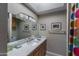 Bright bathroom with a large mirror, modern lighting, white countertops, and colorful shower curtain at 10557 E Fanfol Ln, Scottsdale, AZ 85258