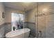 Modern bathroom featuring a freestanding tub, a rainfall shower, and decorative mosaic tiles at 10557 E Fanfol Ln, Scottsdale, AZ 85258