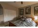 Cozy bedroom with a ceiling fan, decorative pillows, and two vintage prints hanging on the wall at 10557 E Fanfol Ln, Scottsdale, AZ 85258