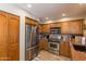 Spacious kitchen featuring stainless steel appliances, wooden cabinets, and granite countertops at 10557 E Fanfol Ln, Scottsdale, AZ 85258