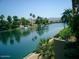 Scenic waterfront view with calm waters, lush greenery, and houses along the shore at 10557 E Fanfol Ln, Scottsdale, AZ 85258