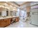 Primary bathroom with double sinks, a soaking tub, walk-in shower, and large window providing natural light at 10672 N 140Th Way, Scottsdale, AZ 85259